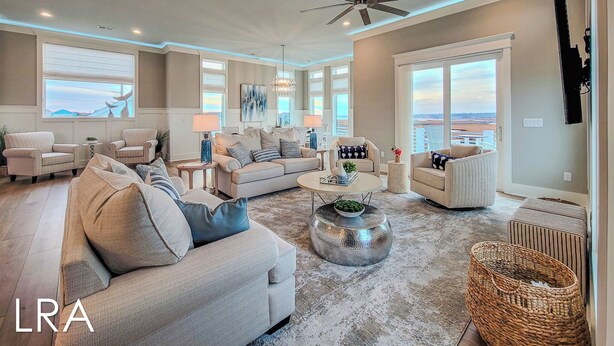 A spacious living room with a high ceiling, large windows, and a view of the beach. - Tide Chateau – Epic Sunsets + Golf Cart Access! (Surf City)
