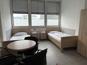 A small, modern room with a bed, a desk, and a chair. - Haus an der Brücke (Munich)