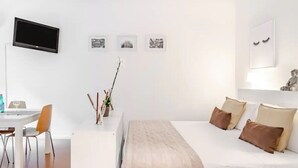 Una habitación de hotel moderna con cama, escritorio y televisor.