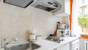 Una cocina moderna con un lavamanos de acero inoxidable, un microondas y un tostador.