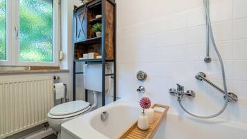 A modern bathroom with a toilet, bathtub, and shower.