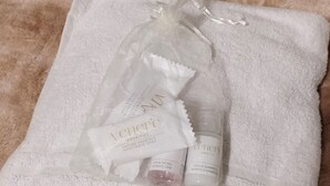 Ein weißes Handtuch mit Toilettenartikeln, darunter eine Shampoo-Flasche und eine Seife.