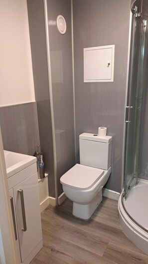 A modern bathroom with a toilet, a shower, and a sink. - Central Sheffield 1-Bed | Walk to Shops & Dining (Sheffield)