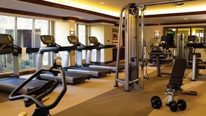 Ett gym med löpband, crosstrainers och utrustning för styrketräning.