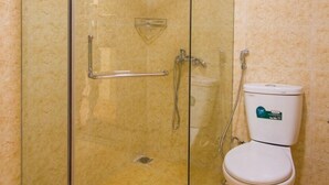 Box doccia in vetro con porta, cabina doccia in vetro e water bianco con etichetta verde.