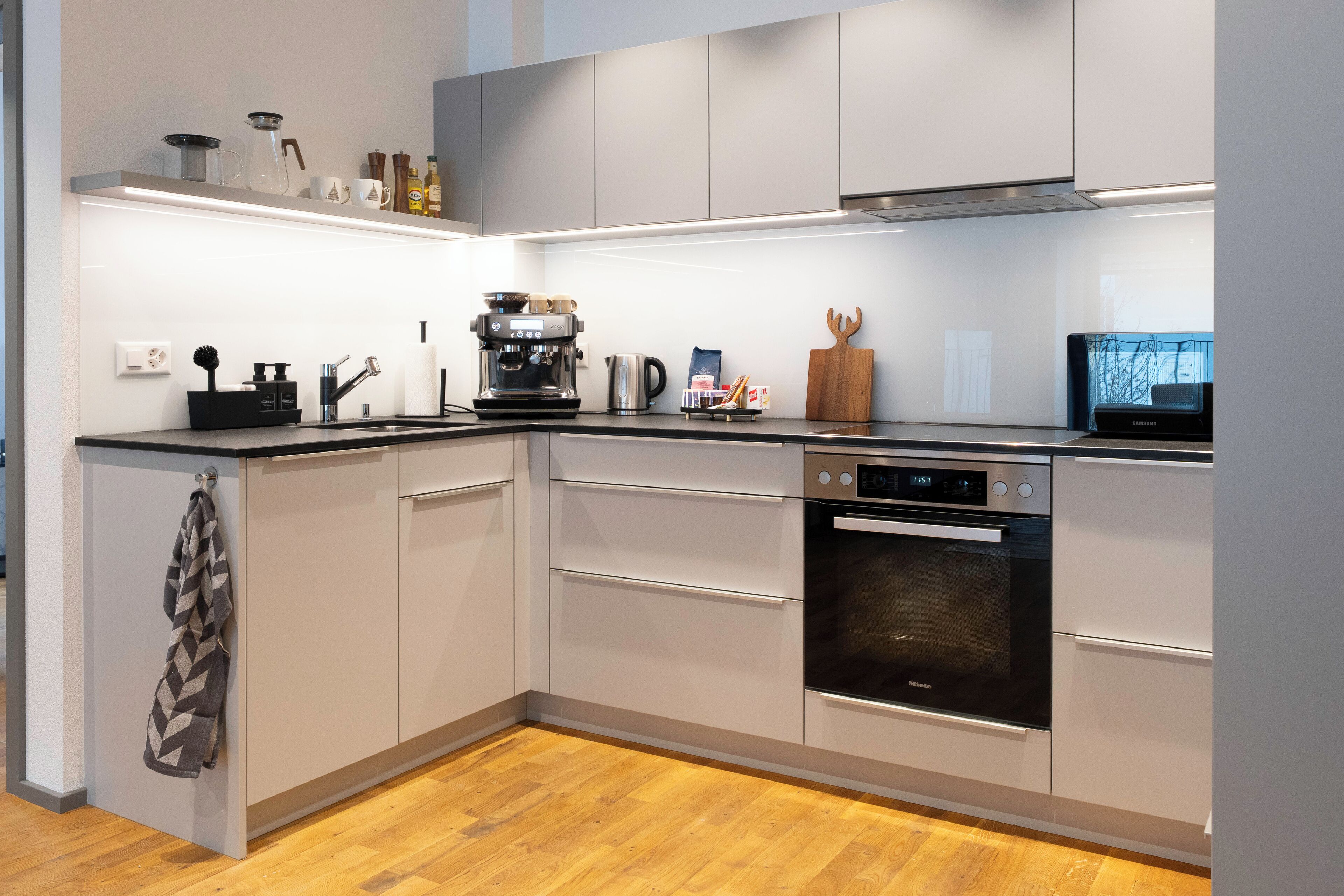 Eine moderne Küche mit Einbauofen, Kaffeemaschine und einem Samsung-Kühlschrank.