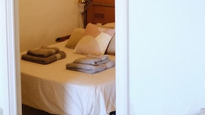 Ein Schlafzimmer mit einem Bett, Kissen und einem Nachttisch mit Lampe.