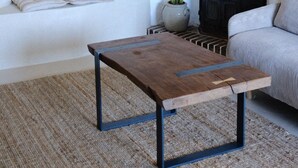 Ein Wohnzimmer mit Kamin, einer Couch, einem Couchtisch und Wandbildern.