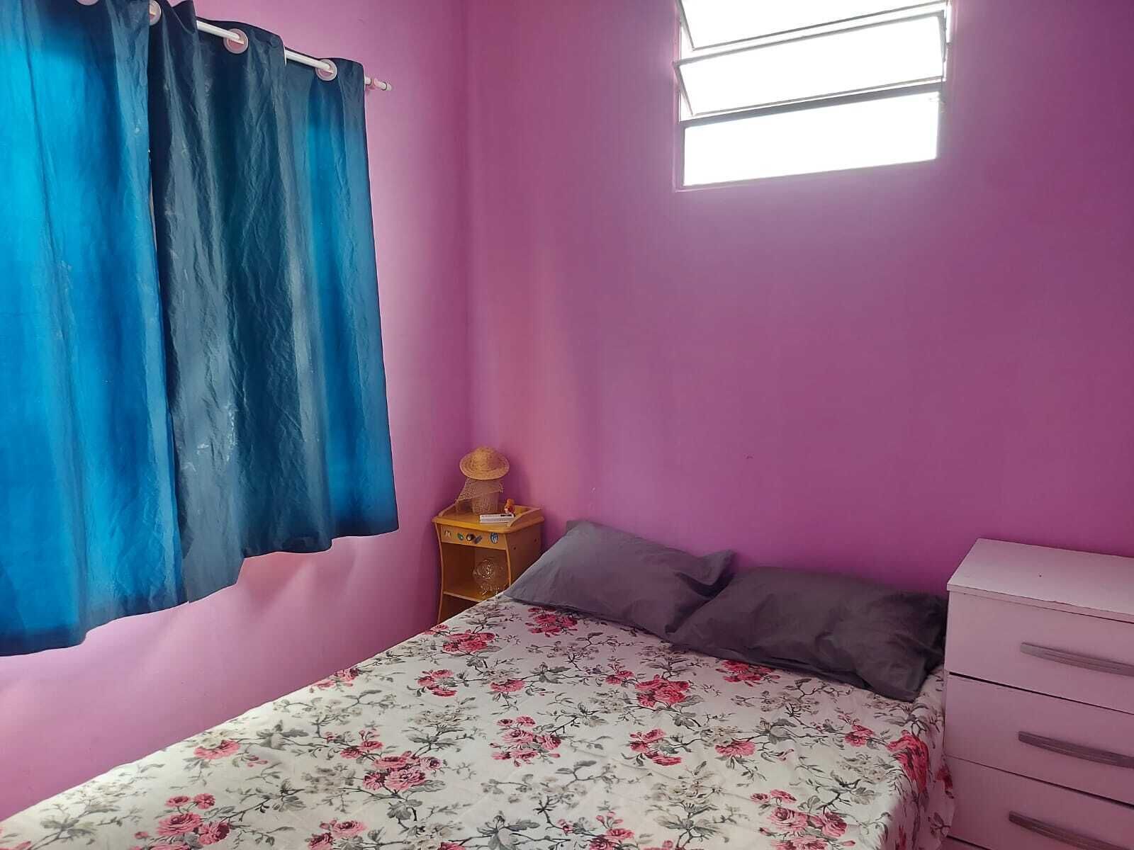 A bedroom with a bed, a dresser, a nightstand, and a window.