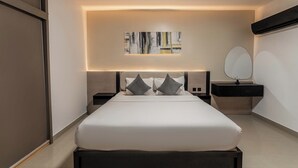 Ein modernes Schlafzimmer mit einem großen Bett, Nachttischen, einem Wandbild und einem runden Spiegel.