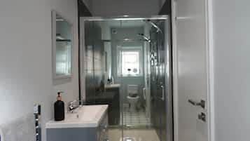 Chuveiro, toalhas de banho, sabonete, papel higiênico