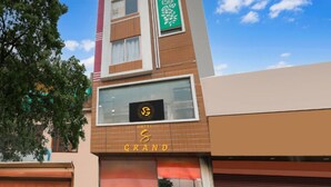 A hotel named 'Grand' with a modern architectural design, featuring a prominent logo on the facade and a green decorative panel. - Hotel S Grand (Prayagraj)