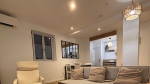 Ein modernes Wohnzimmer mit einer Couch, einem Sessel und einem Couchtisch.