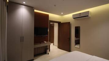Ein Hotelzimmer mit Bett, Kleiderschrank, Fernseher und Klimaanlage.