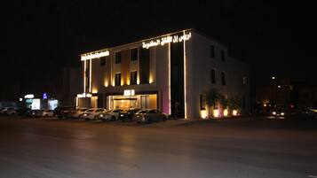 Vista frontal de la propiedad por la tarde o noche