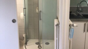 Et moderne badeværelse med bruseniche, toilet og vask.