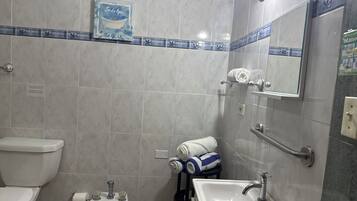 Een badkamer met toilet, bidet, wastafel en handdoekhouder.