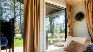 A bedroom with a bed, curtains, and a view of the outdoors. - "Afkar" - 900m from the sea by Interhome (Løkken)