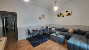 Een moderne woonkamer met een bank, salontafel en eethoek.