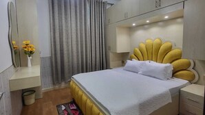 Een moderne slaapkamer met een bed, nachtkastjes, een spiegel en een kledingkast.