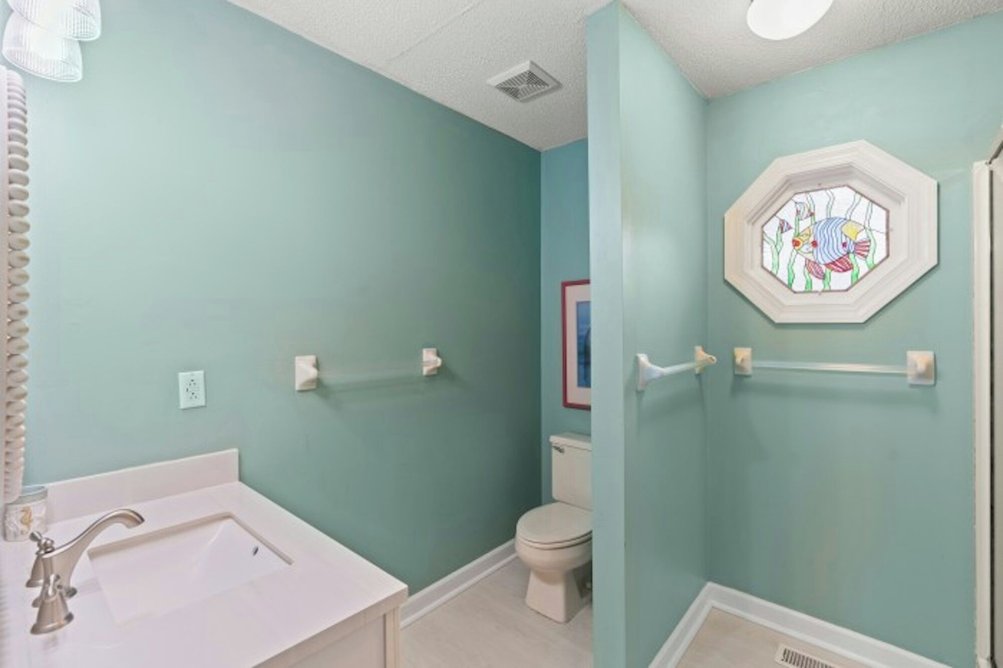 A bathroom with a white bathtub, a toilet, and a shower area.