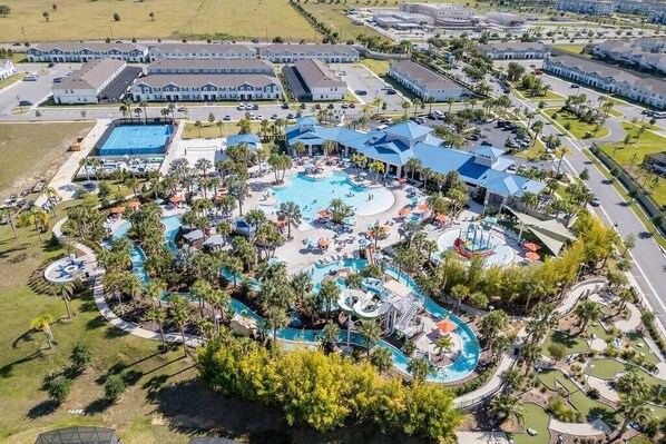 An aerial view of a resort with multiple swimming pools, a large central pool, and a variety of outdoor and indoor amenities. - 5BD Windsor Island Resort Disney Themed (WI 3858) (Davenport)