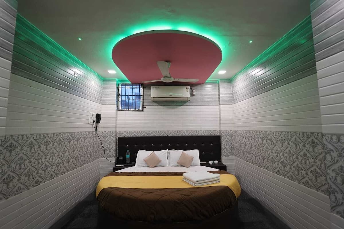 Ein Hotelzimmer mit Bett, Deckenventilator und einem Fenster mit Gitterstäben.