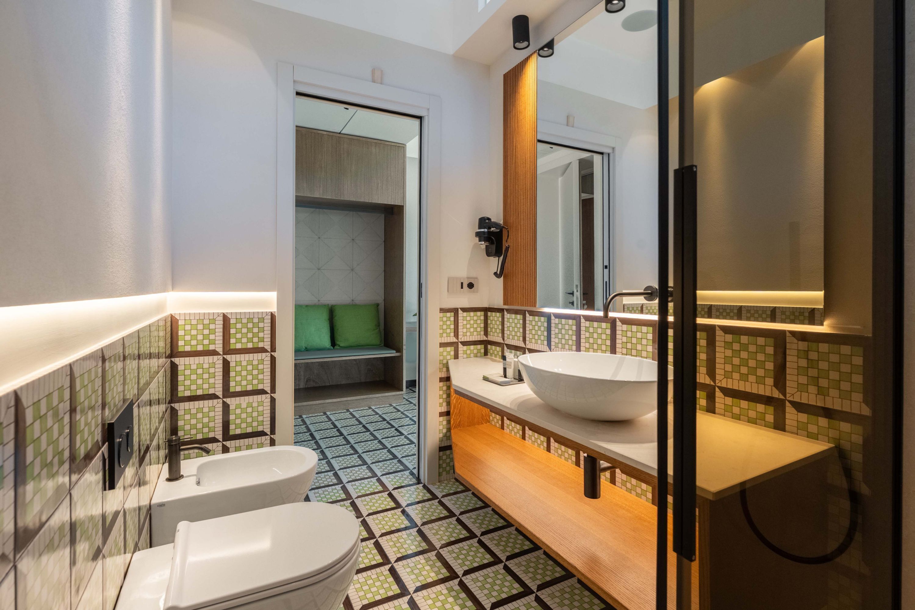 A modern bathroom with a large mirror, two sinks, and a shower area.