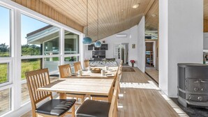 Une cuisine spacieuse dotée d’un grand îlot central, d’un plancher en bois et offrant une vue sur l’extérieur.