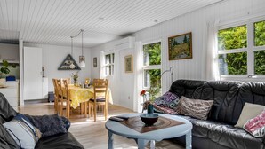 A spacious living room with a black leather sofa, a round coffee table, and a dining area with wooden chairs and a yellow tablecloth. - "Matias" - 30km from the sea by Interhome (Toftlund)