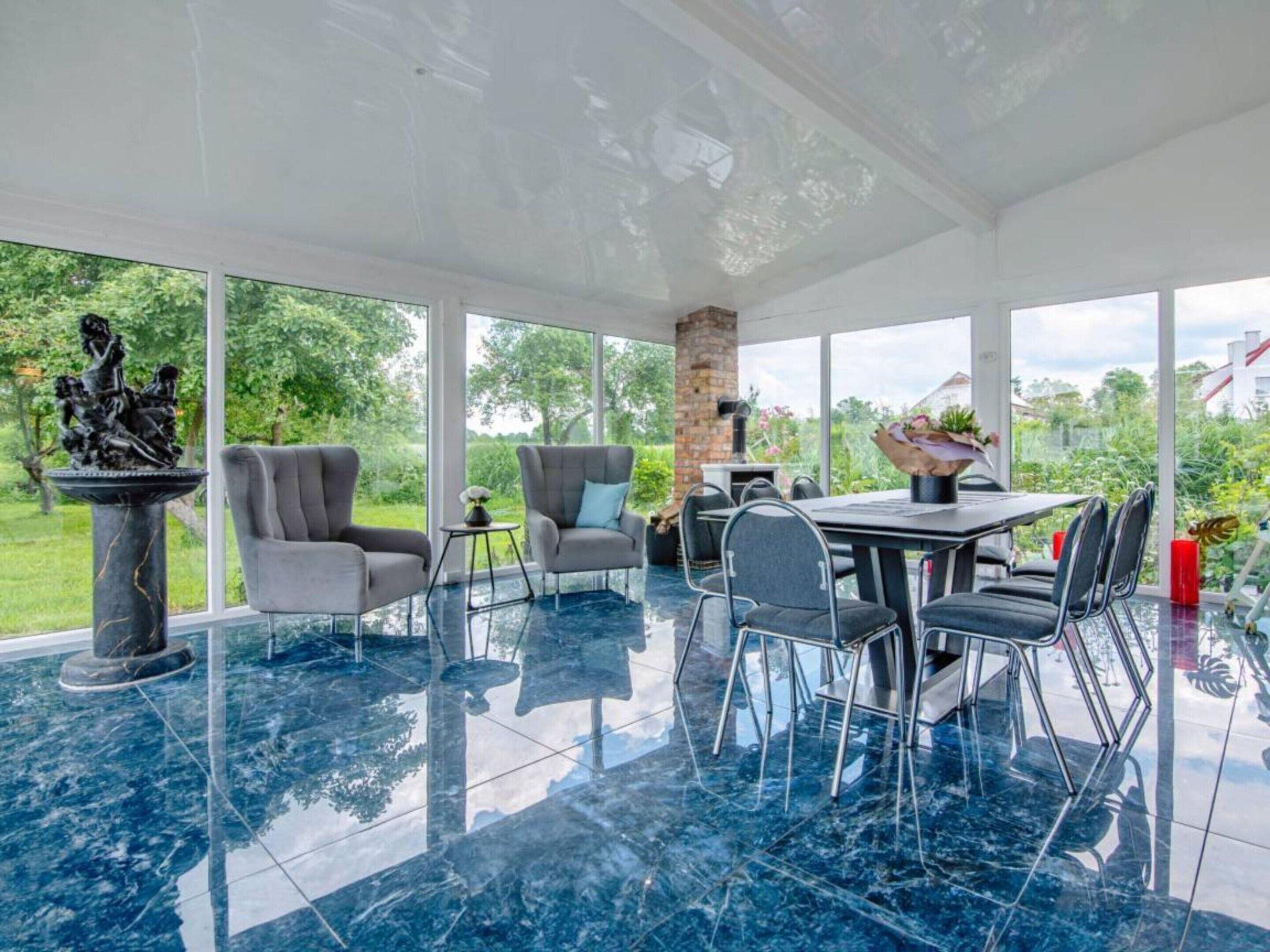 Un espace intérieur spacieux comprenant une table à manger, des chaises et une statue.