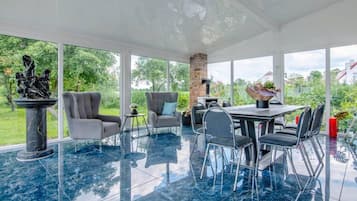 Un espacio interior amplio con una mesa de comedor, sillas y una estatua.