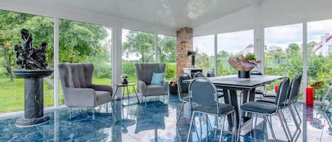 Un espacio interior amplio con una mesa de comedor, sillas y una estatua.