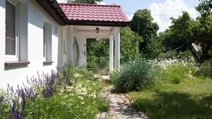 A white building with a red-tiled roof and a stone pathway leading to a covered entrance. - Comfortable House With a Swimming Pool and Sauna (gmina Dobra)