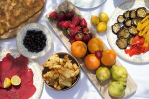 A table with various food items including bread, strawberries, oranges, blueberries, and pears.