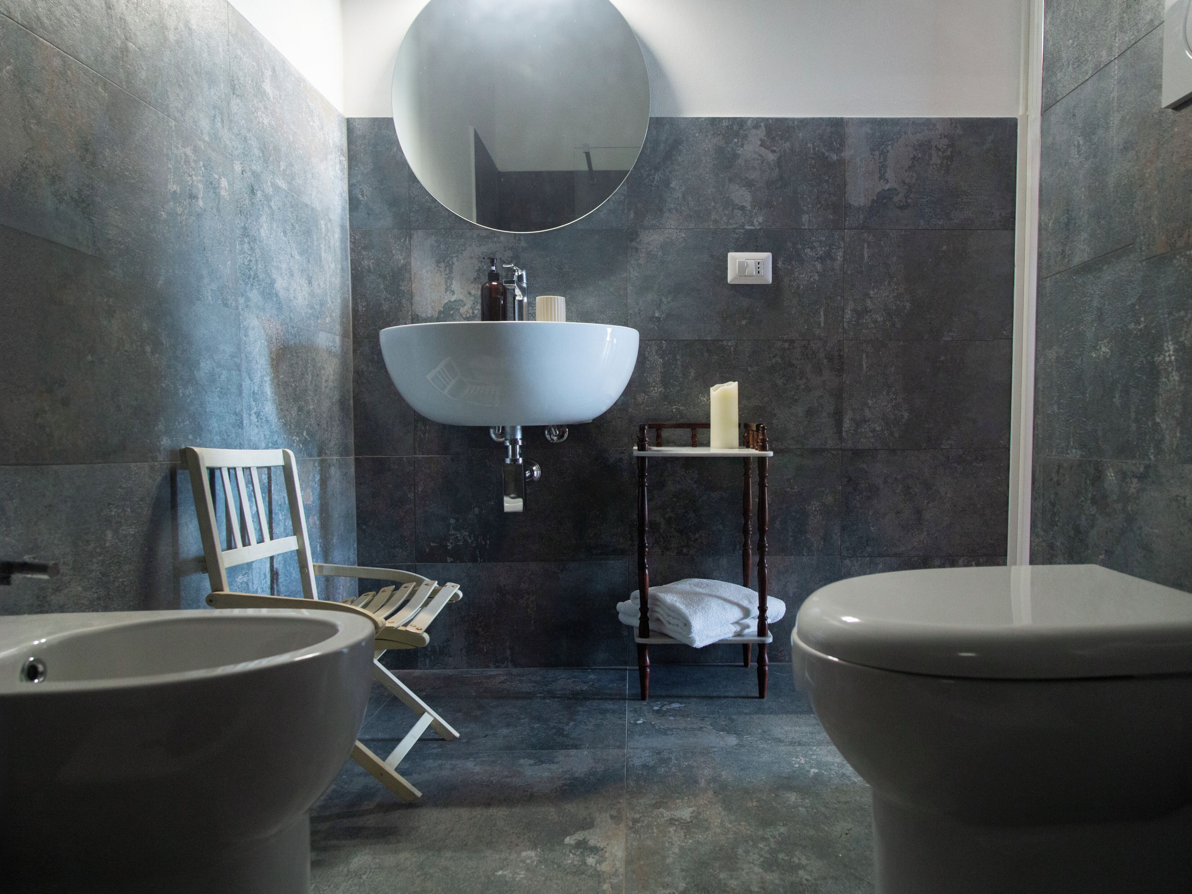 Ein modernes Badezimmer mit zwei Waschbecken, einem Spiegel und einer Toilette.