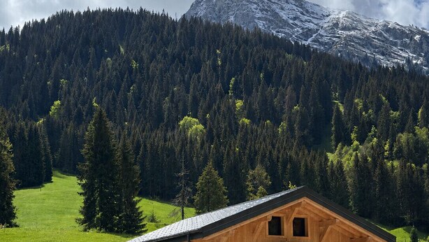A wooden chalet with a stone foundation, a balcony, and a mountain backdrop. - Le Gypaète, Prodains, Morzine (Morzine)