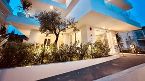Un hôtel moderne à l’architecture imposante, doté de plusieurs étages, d ’un espace extérieur aménagé et d’une entrée bien éclairée.
