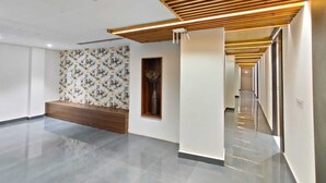 A spacious hallway with a wooden slatted ceiling, a patterned wall, and a reception desk. - Hotel M.K (Pathankot)