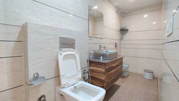 A modern bathroom with a toilet, bidet, and sink.