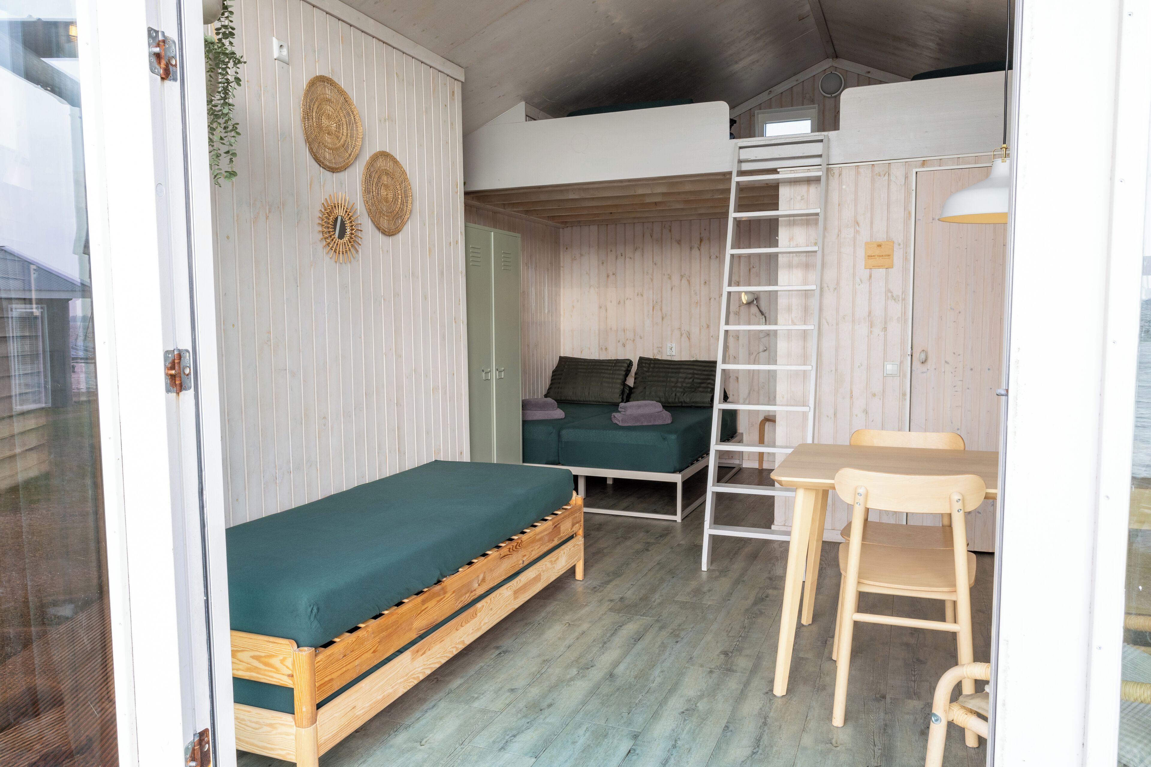 A compact room with a bunk bed, a small desk, and a chair.