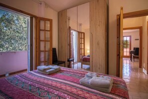 A bedroom with a large bed, two towels, a chair, and a desk. - Vacation House Nuraghes (Pittulongu)