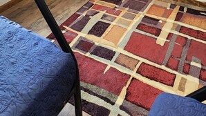 A room with a black metal rack, a patterned rug, and two blue upholstered chairs. - 3324 Barbury LN, 37931 (Knoxville)