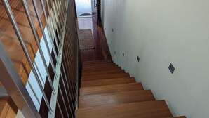Una escalera de madera con barandilla de metal que conduce a una plataforma.