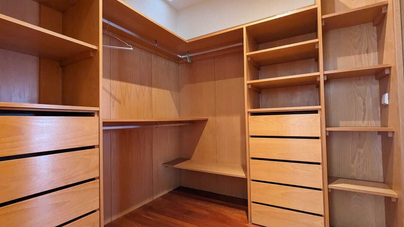 Et garderobeskab med flere hylder og skuffer i træ.