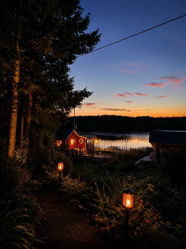A lakeside cabin with a dock, surrounded by trees and a clear sky. - Swedish Magic – An Exclusive Retreat by the Lake with a Private Dock, Boat, and Guest House (Belganet)