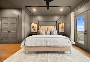 A bedroom with a four-poster bed, a large window, and a view of the outdoors. - Private Heated Pool, Hot Tub & Game Room Getaway (Hot Springs)