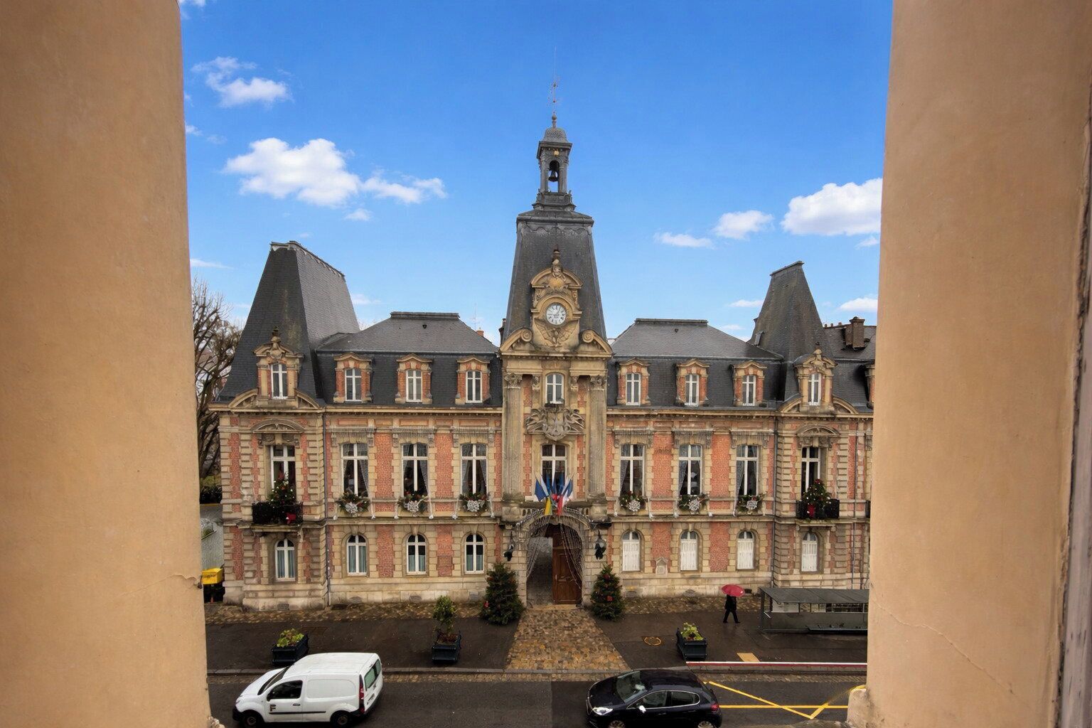 A large, historic building with a prominent clock tower, symmetrical windows, and a central entrance.
