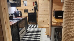 A kitchen with a checkered floor, wooden cabinets, a stove, and a microwave. - Cozy 1-bedroom bunk style apartment Game Rm/Gym/Stream in historic McDowell! (McDowell)