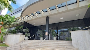 Un bâtiment moderne doté d’une entrée incurvée, d’une façade en verre et d’un escalier menant à l’entrée.